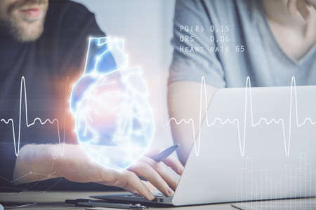 Heart drawing with man working on computer on background. Medical concept. Double exposure.の写真素材