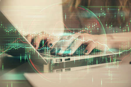 Double exposure of woman hands typing on computer and forex chart hologram drawing. Stock market...