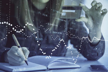 Double exposure of woman on-line shopping holding a credit card and data theme hologram drawing....