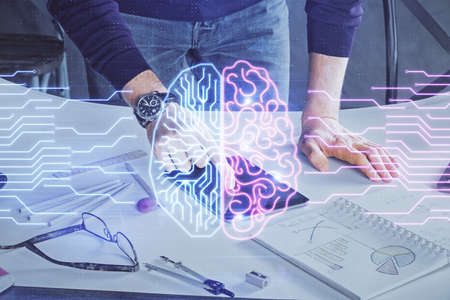 Double exposure of man's hand holding and using a digital device and brain hologram drawing. Data...