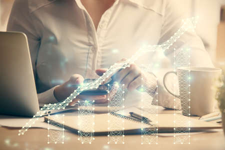 Double exposure of forex chart sketch hologram and woman holding and using a mobile device....