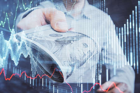 Multi exposure of financial graph drawing hologram and USA dollars bills and man hands. Analysis...
