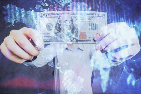 Multi exposure of financial graph drawing hologram and USA dollars bills and man hands. Analysis...