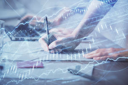 Multi exposure of woman hands typing on computer and financial chart hologram drawing. Stock market...