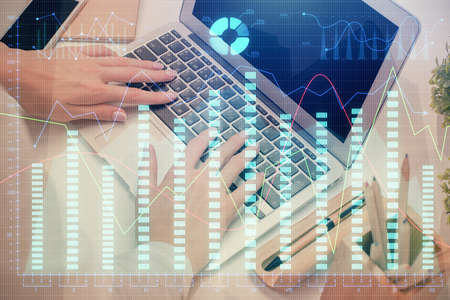 Double exposure of woman hands typing on computer and forex chart hologram drawing. Stock market...