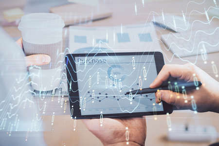 Double exposure of man's hands holding and using a phone and financial chart drawing. Market analysis concept.の写真素材