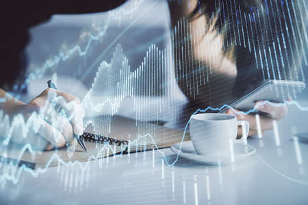 Double exposure of forex graph sketch hologram and woman holding and using a mobile device. Stock...