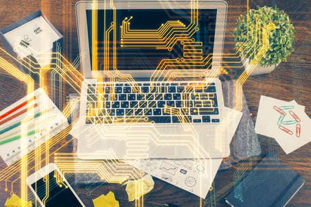 Computer on desktop in office with technology theme hologram. Multi exposure. Tech concept.