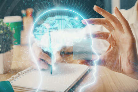 Multi exposure of writing hand on background with brain hologram. Concept of learning.の写真素材