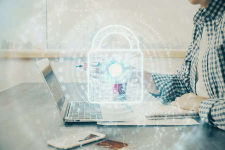 Double exposure of lock icon with man working on computer on background. Concept of network security.の写真素材