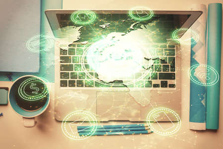 Social network hologram drawings over computer on the desktop background. Top view. Multi exposure....