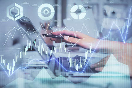 Multi exposure of woman hands typing on computer and financial graph hologram drawing. Stock market...