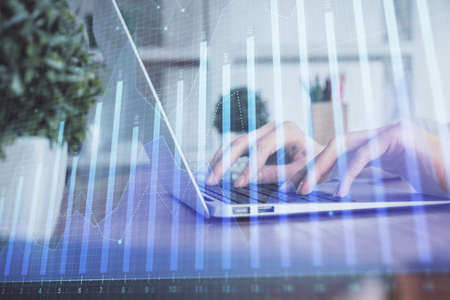 Double exposure of woman hands typing on computer and forex chart hologram drawing. Stock market invest concept.の写真素材