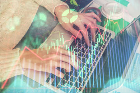 Double exposure of woman hands typing on computer and forex chart hologram drawing. Stock market...