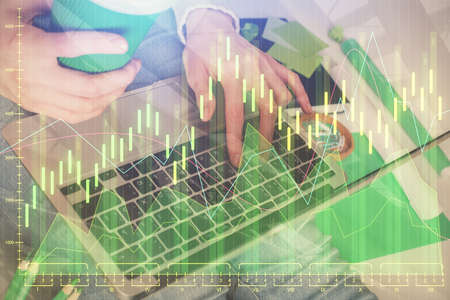 Double exposure of woman hands typing on computer and forex chart hologram drawing. Stock market...