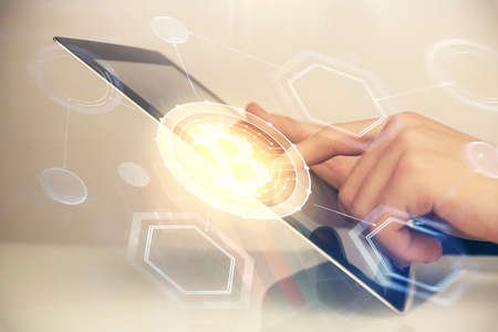 Double exposure of man's hands holding and using a phone and crypto currency blockchain theme...
