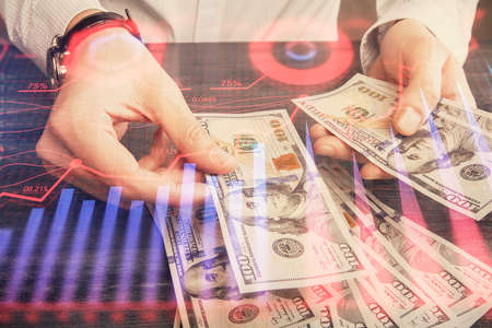 Multi exposure of financial graph drawing hologram and USA dollars bills and man hands. Analysis concept.の写真素材