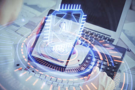 Double exposure of man's hand holding and using a digital device and data theme hologram drawing. Technology concept.の写真素材