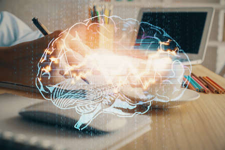 Multi exposure of writing hand on background with brain hologram. Concept of self learning.の写真素材