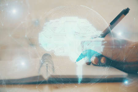 Double exposure of writing hand on background with brain hologram. Concept of learning.