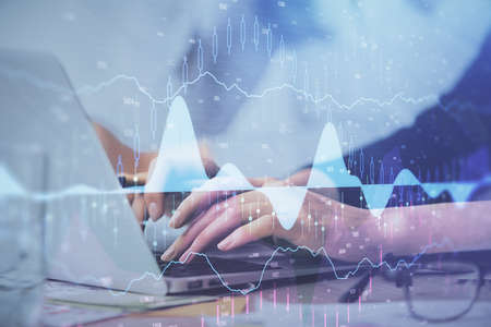 Multi exposure of woman hands typing on computer and financial graph hologram drawing. Stock market...