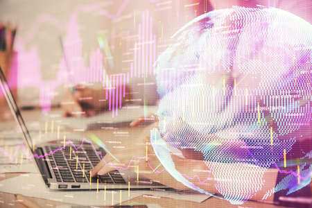 Multi exposure of woman hands typing on computer and financial chart hologram drawing. Stock market...