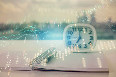 Double exposure of financial graph drawings and desk with open notebook background. Concept of forex...