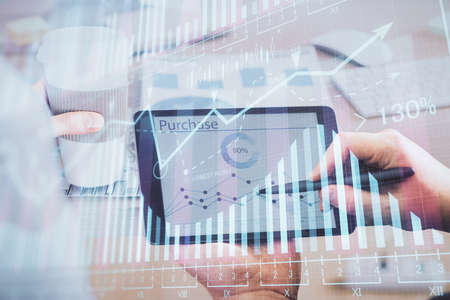 Double exposure of man's hands holding and using a phone and financial chart drawing. Market...