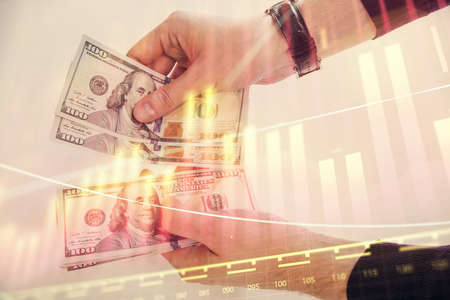 Multi exposure of financial graph drawing hologram and USA dollars bills and man hands. Analysis...