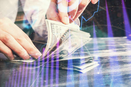Multi exposure of forex graph drawing hologram and USA dollars bills and man hands. Technical...