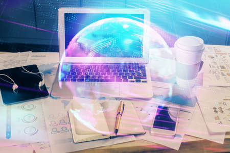 Computer on desktop in office with technology theme hologram. Multi exposure. Tech concept.