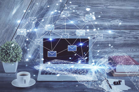 Desktop computer background in office and flying envelops hologram drawing. Double exposure....