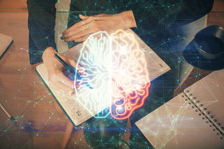 Double exposure of writing hand on background with brain hologram. Concept of learning.