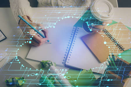 Double exposure of hands making notes background with technology and digital coding huds. Data...