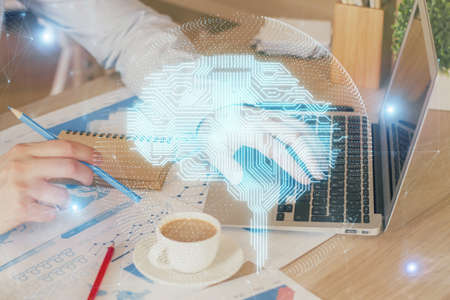 Businessman with computer background with brain theme hologram. Concept of brainstorm. Multi...