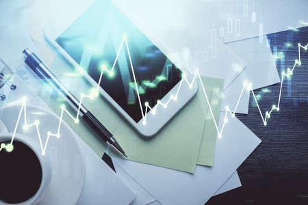 Multi exposure of forex graph hologram over desktop with phone. Top view. Mobile trade platform...