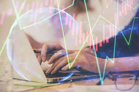 Multi exposure of woman hands typing on computer and financial graph hologram drawing. Stock market...