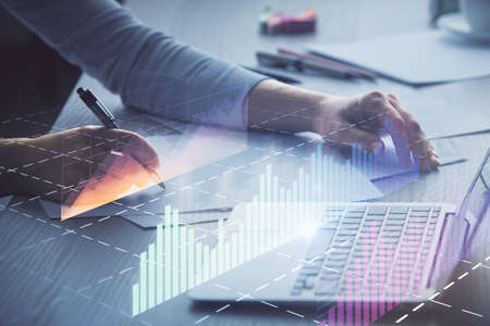 Double exposure of businesswoman hands typing on computer and forex chart hologram drawing....