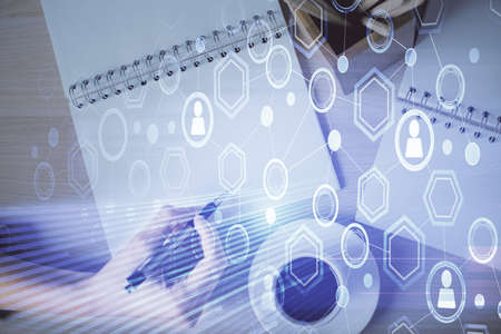 Social network theme hologram over hands taking notes background. Concept of global international...