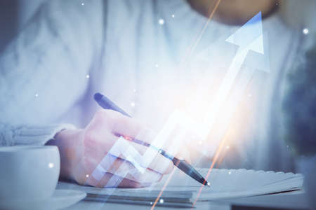 Blue arrow over woman's hands taking notes background. Concept of success. Double exposure
