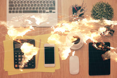 Double exposure of business theme hologram over desktop with phone. Top view. Mobile international...