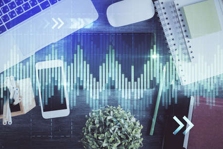 Double exposure of forex chart hologram over desktop with phone. Top view. Mobile trade platform...
