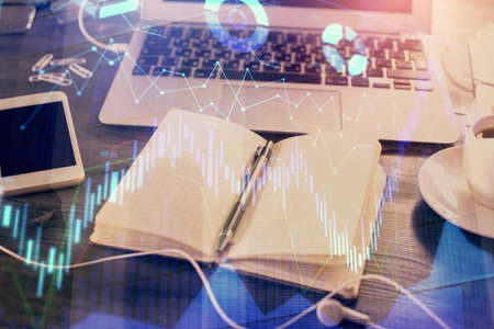 Multi exposure of financial graph drawings and desk with open notebook background. Concept of forex