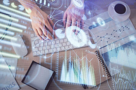Double exposure of man's hands typing over computer keyboard and data theme hologram drawing. Top...