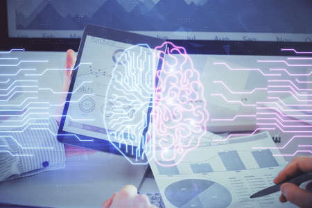 Double exposure of man's hand holding and using a digital device and brain hologram drawing. Data...
