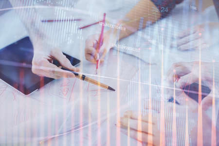 Double exposure of forex graph drawing and man and woman working together holding and using a mobile...