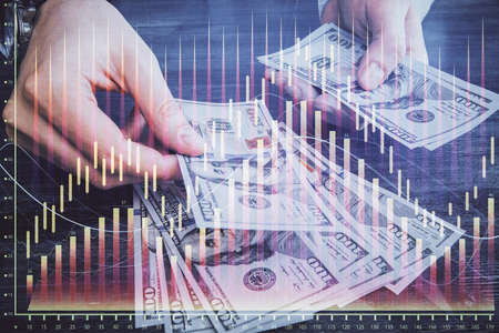 Multi exposure of financial graph drawing hologram and USA dollars bills and man hands. Analysis concept.の写真素材