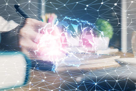 Multi exposure of writing hand on background with brain hologram. Concept of self learning.