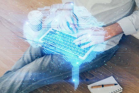 Businessman with computer background with brain theme hologram. Concept of brainstorm. Multi...