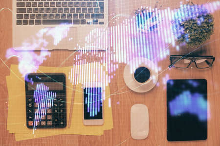 Double exposure of business theme hologram over desktop with phone. Top view. Mobile international...